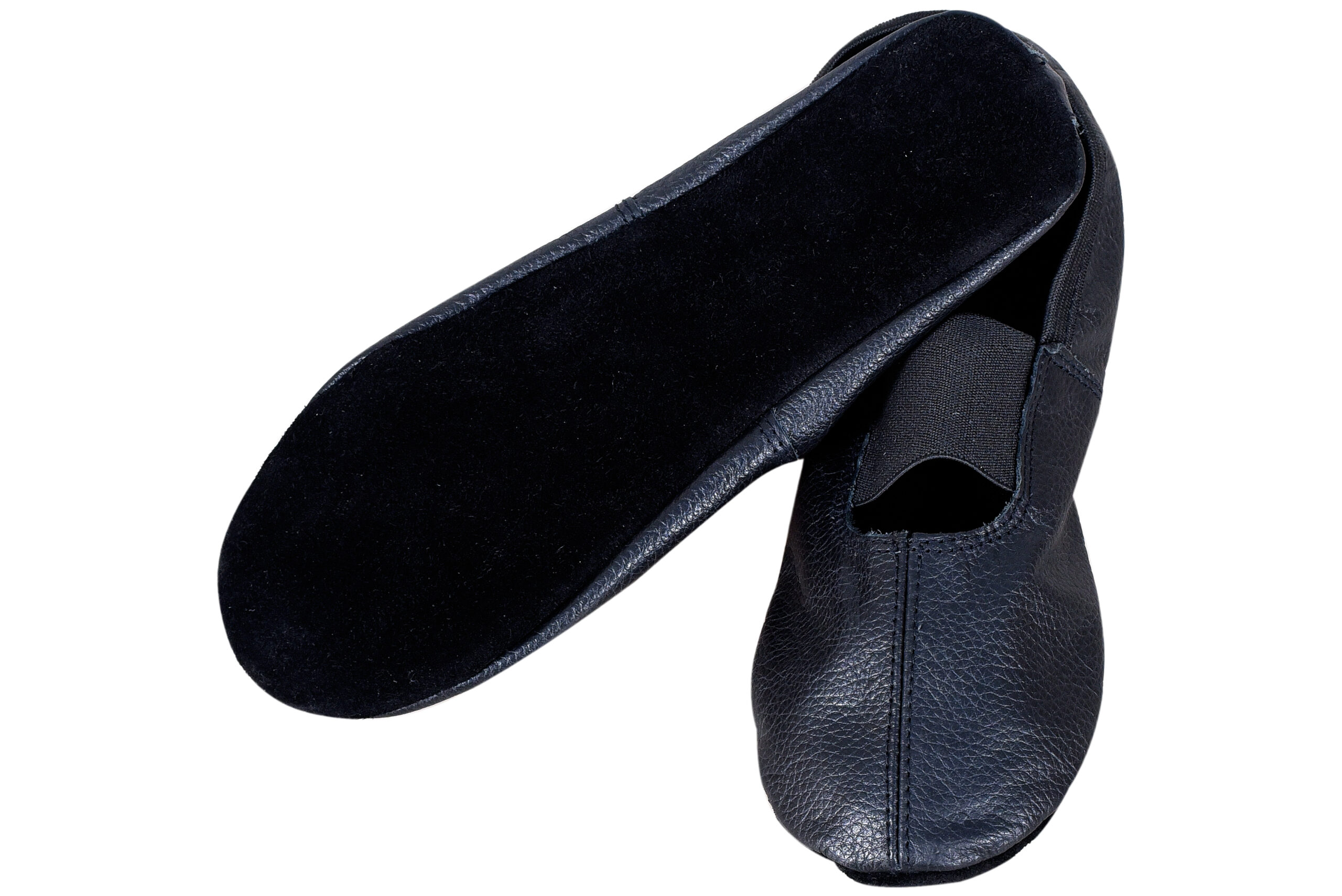 Black leather gymnastics shoes with soft suede soles and an elastic instep band, shown overlapping on a white background.